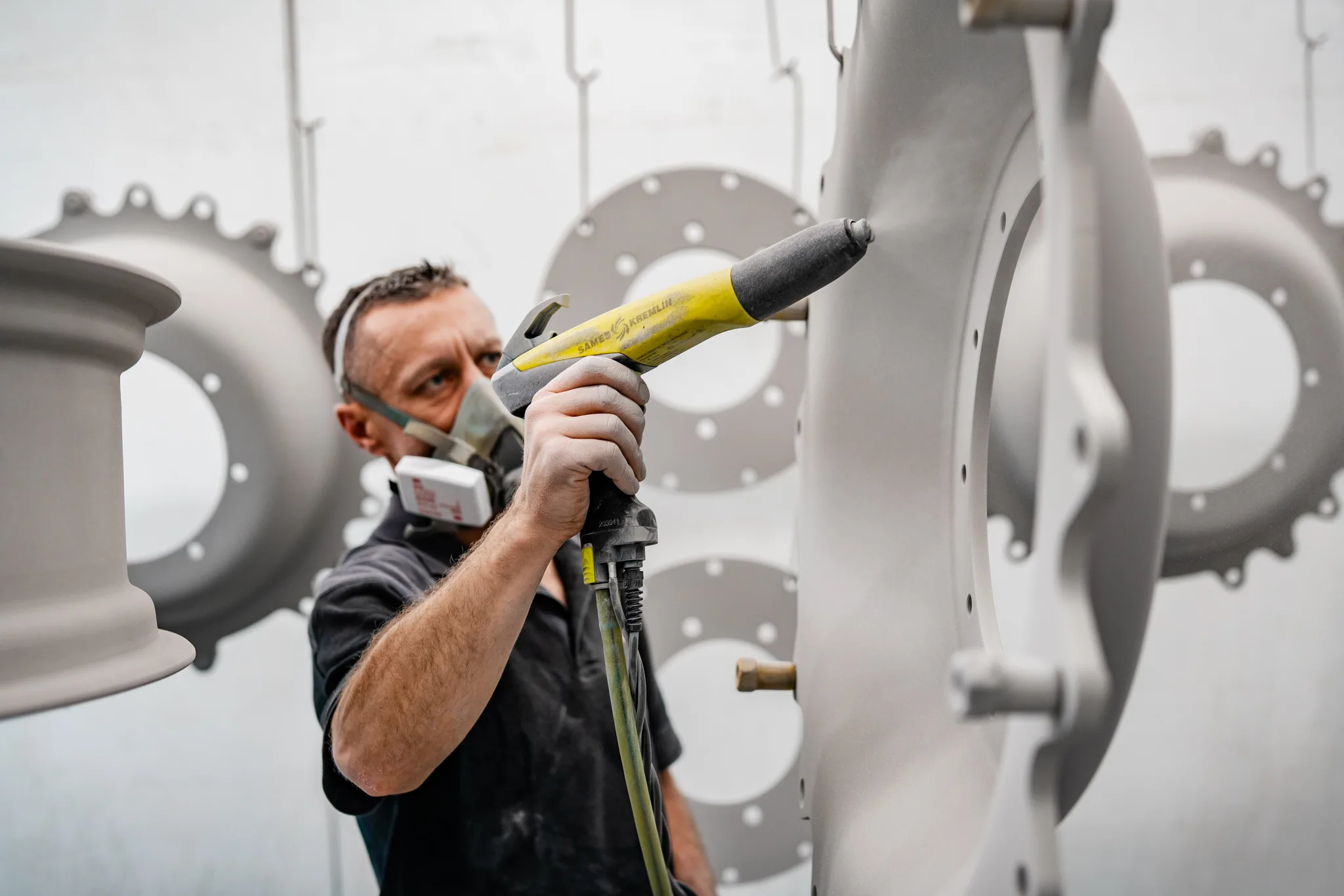 Portretfoto van medewerker van BMS Coating met spuitpistool in industriële spuitcabine